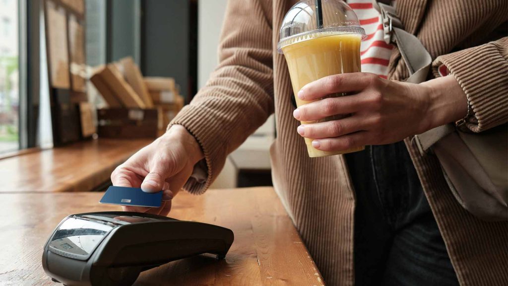 Person betalar på en kortterminal i ett café