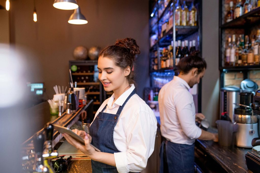 Personer står i en restaurang och jobbar.